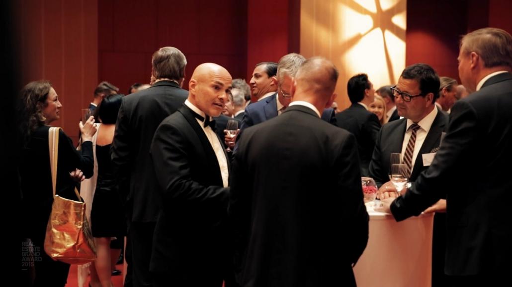 It's always a good idea to include participant interactions in an event movie, as seen here in this image: Gathered at a round table, four entrepreneurs are talking.