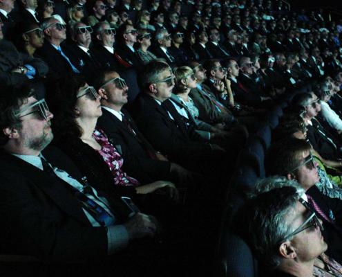 people in a room watching a 3d dilm production