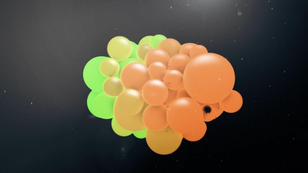 Depicted in this image is a multitude of orange and green bubbles that form a unit, moving organically.