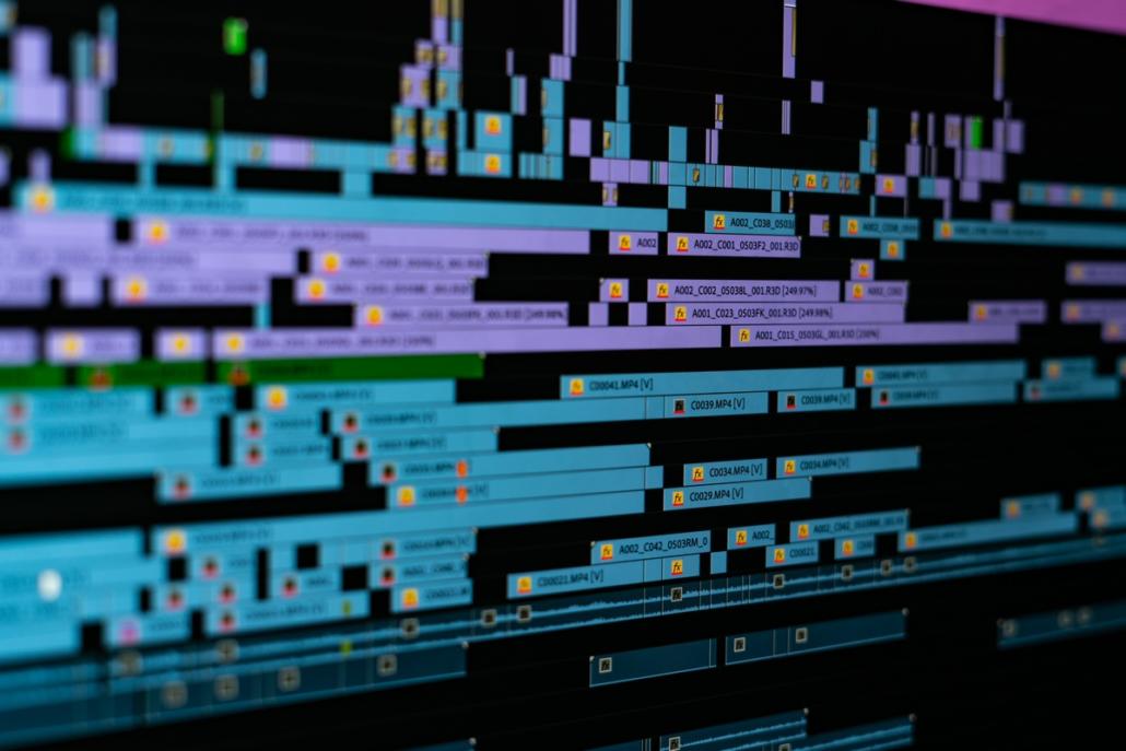 A complex timeline is common for a film editor. The image shows a close-up of a timeline with a large number of different tracks, so that it fills the entire image. In slightly oblique perspective and shallow depth of field, the center area of the image is in focus.
