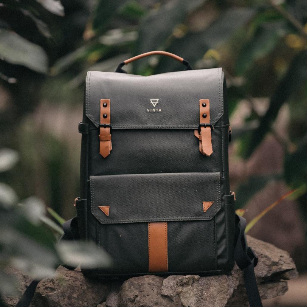 Skillfully create a product video for the company Vinta, as shown in this packshot: You can see a photo backpack of the brand, which is shown in the wild, frontally, placed on a pile of stones.