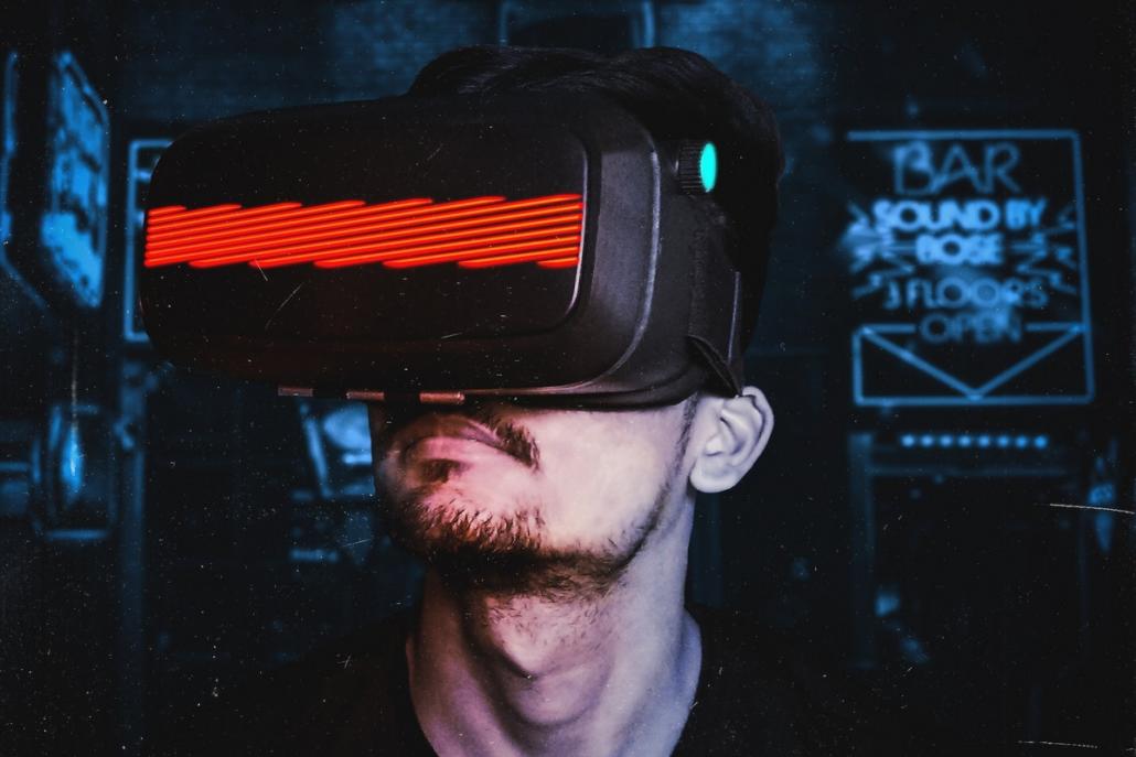 We see the face of a man during a test run in an animation studio. He is in a dark room and is wearing VR glasses that glow red.