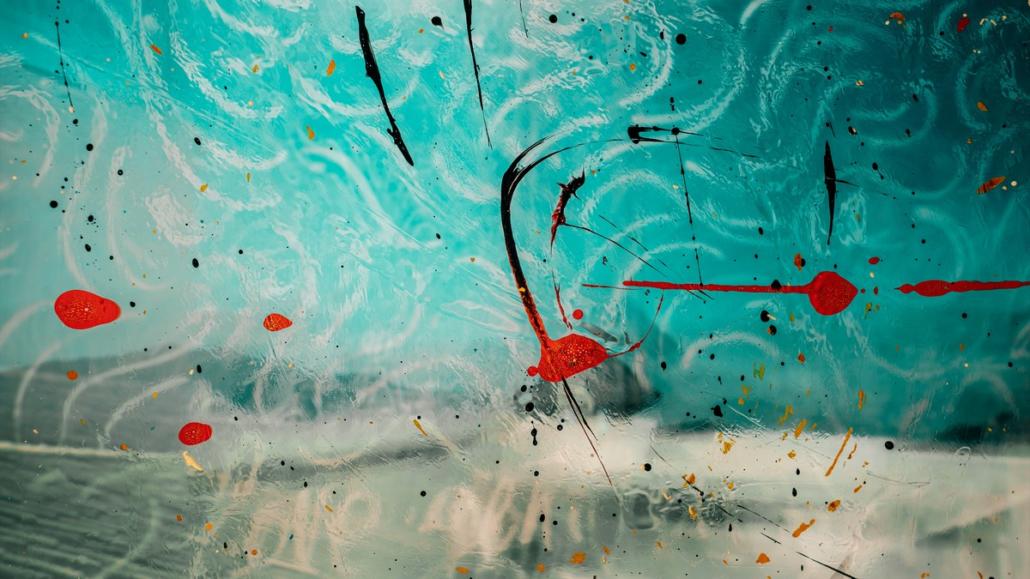 An oil painting can be seen, in which turquoise, white, black and red paint has been used to create an impressive abstract world. In its composition, this picture evokes associations with an aquarium.