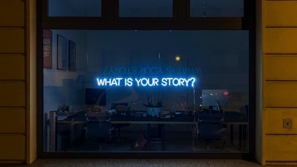 On a window front of an explainer video company is a glowing blue sign consisting of the phrase 