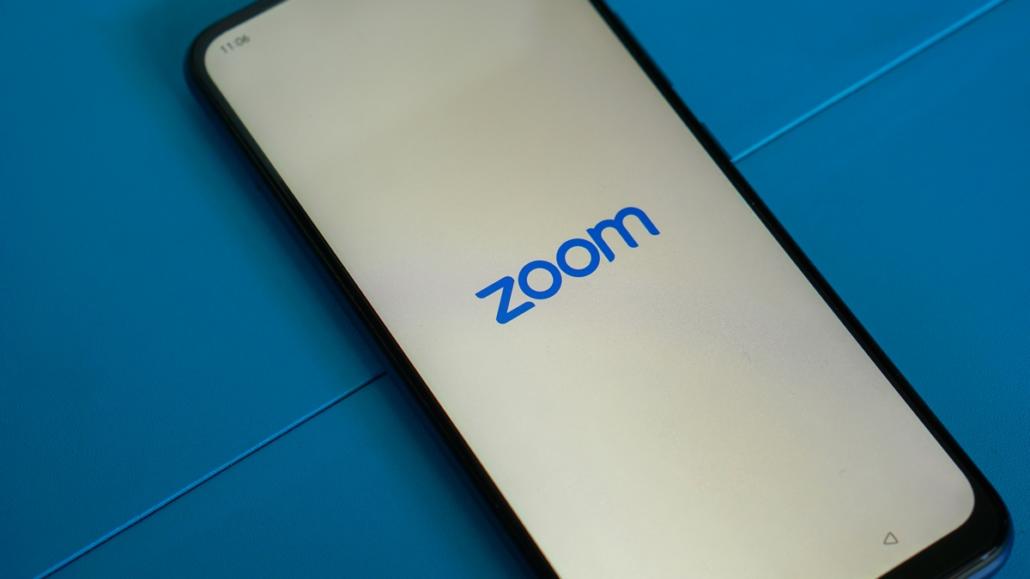 A smartphone lies on a blue surface and we see the name of the smartphone application 